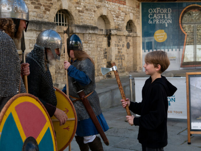 A child learns how to use a viking axe